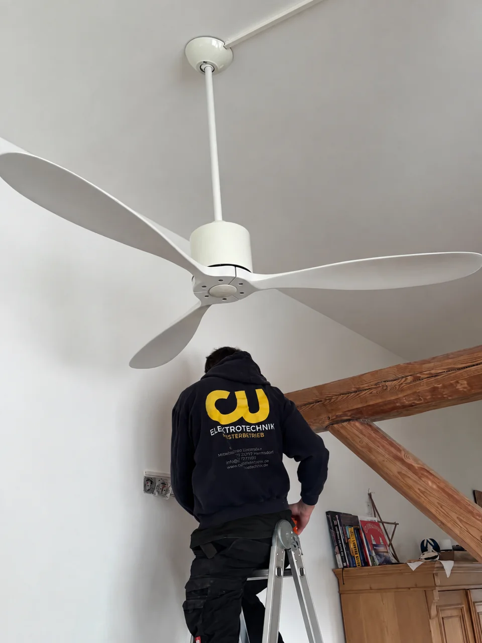 CU Elektrotechnik bei der Montage eines weißen Deckenventilators mit Zuleitung im Kabelkanal